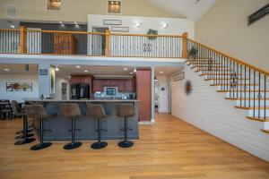 a basement with a bar with stools and a staircase at Lakeshore Retreat with Lake Lanier views & hot tub in Landrum