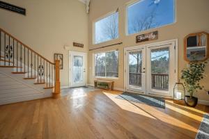 a large living room with a staircase and windows at Lakeshore Retreat with Lake Lanier views & hot tub in Landrum +69 photos