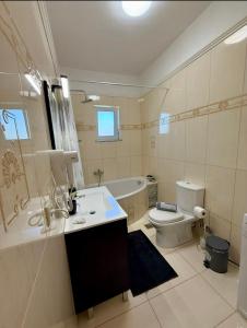 a bathroom with a sink and a toilet and a tub at Serenity apartment sea view in Souda
