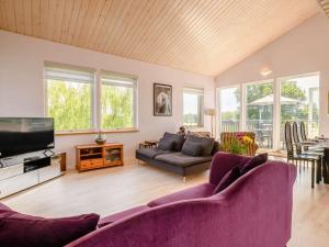 a living room with two purple couches and a tv at 3 Bed in Hopton 88649 in Fritton Norfolk