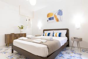 a bedroom with a large bed with white sheets and pillows at Casa Zio Lele in Cefalù