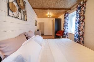 a bedroom with a white bed in a room at Les cols in Sainte-Marie-de-Cuines