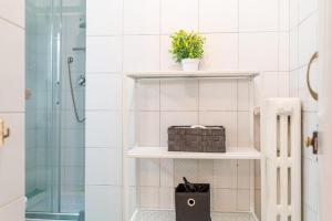 un bagno con una mensola con un cestino e una doccia di Charm in Piazza Castello a Torino Altre 24 foto