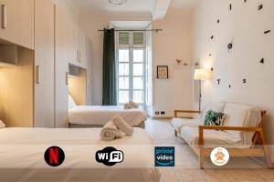 una camera d'albergo con due letti e un divano di Charm in Piazza Castello a Torino