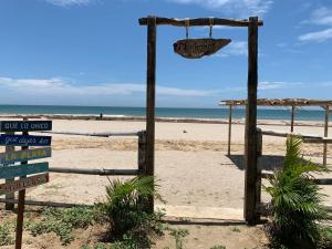 a sign on a beach with the ocean in the background at Casa Montemar in Caleta Grau