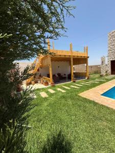 a house with a wooden deck next to a swimming pool at Stone Kaouki's House in Sidi Kaouki