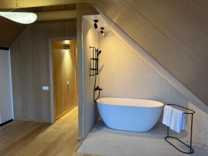 a bathroom with a tub in the middle of a room at Peipsi Villas by Estonia Premium Living in Raja +49 photos