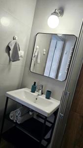 a bathroom with a white sink and a mirror at Apartamenty Dana in Pustkowo