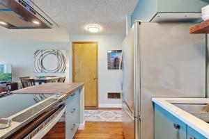 a kitchen with a refrigerator and a dining room at Ocean View Vacay in Rockaway Beach +9 photos