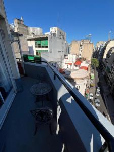 a balcony with two tables and a view of a city at Un lugar unico, cerca del Colon in Buenos Aires