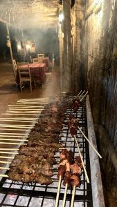 ein Haufen Essen auf einem Grill in einem Zimmer in der Unterkunft Authentic Desert Camp - Al Wasil in Al Wāşil + 40 Fotos