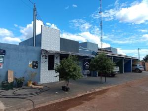 a building with two trees in a parking lot at FlatsMedrado Hotel in Confresa