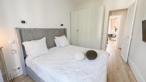 - une chambre avec un lit blanc et un chapeau dans l'établissement Neuilly Étoilé - 2 Personnes - Luxe Proche Métro - Direct Paris, à Neuilly-sur-Seine
