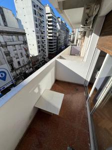 a white bench sitting on the balcony of a building at Hermoso, con vista al obelisco in Buenos Aires