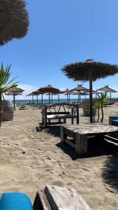 a group of picnic tables on the beach with umbrellas at Canet Plage - Maison 3 chambres in Canet-en-Roussillon