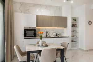 a kitchen with a table with chairs and a microwave at Njivice Coastal Oasis in Njivice
