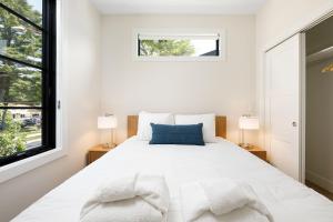 a white bedroom with a large bed with two lamps at Hamilton Place Bayside Building 301 B in Traverse City