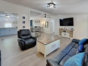 Una sala de estar con un sofá y sillas y un televisor. en Island Club #13, en Put-in-Bay