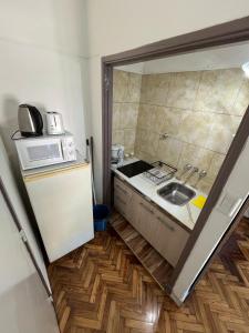 Una pequeña cocina con fregadero y microondas. en Luminoso y Cálido con Balcón a la calle, en Buenos Aires