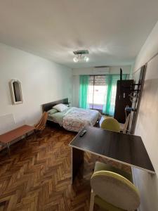Habitación con cama, escritorio y sillas. en Luminoso y Cálido con Balcón a la calle, en Buenos Aires