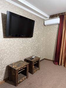 a room with two tables and a flat screen tv at GT Hotel in Chernivtsi