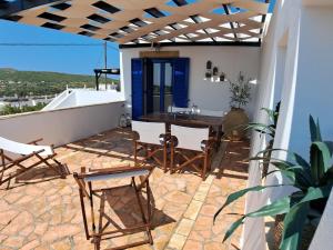 a patio with a table and chairs on a house at DaGiorgio in Pitsiniánika