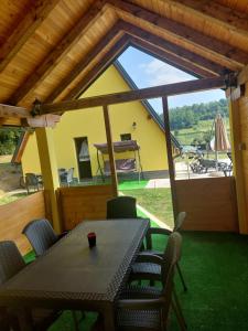 a table and chairs on the porch of a house at Vikendica Buzadzija M&N 