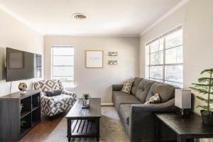 a living room with a couch and a tv at Whitesboros Hidden Gem Cozy Downtown Haven in Whitesboro