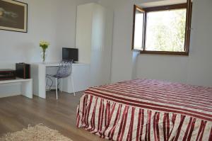 a bedroom with a bed and a desk and a window at Country House Torrenera in Morro dʼOro