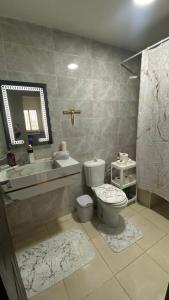 a bathroom with a toilet and a sink and a mirror at Appartement meublé en location nuitée in El Jadida