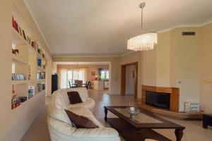 ein Wohnzimmer mit einer weißen Couch und einem Tisch in der Unterkunft Roda Luxury Beach House in Roda