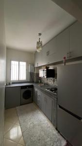 a large kitchen with white cabinets and a stove at Appartement meublé en location nuitée in El Jadida