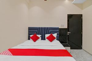 a bed with red pillows in a room at Hotel O S R Guest House in Sakardarā +18 photos