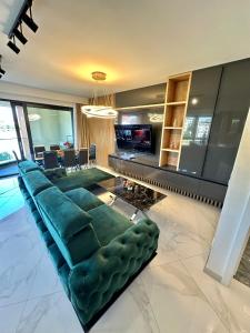 a living room with a green couch and a television at Ilidža Sky Royal Residences in Sarajevo