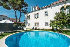 a swimming pool in front of a house at Villa Vasco da Gama in Cascais