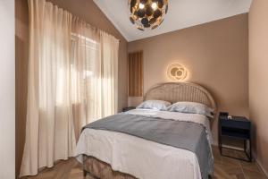 リエカにあるAdastra apartments with private parking and floor heatingのベッドとシャンデリアのある寝室