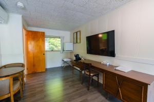 a room with a desk with chairs and a tv on the wall at Mount Coolidge Motel in Lincoln