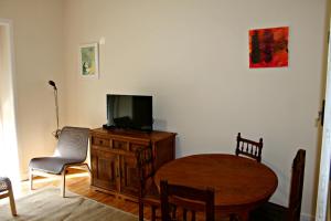 a living room with a television and a table and chair at Sintra - Casa da Portela in Sintra