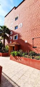 アロナにあるAmarilla Rockのヤシの木が目の前に見える赤レンガ造り +9枚の写真