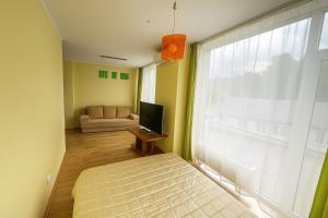 a bedroom with a bed and a couch and a window at RÜÜTLI City Center Apartment in Pärnu