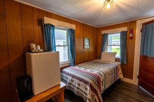 a small bedroom with a bed and two windows at Mount Coolidge Motel in Lincoln +41 photos