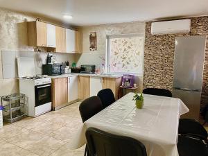 a kitchen with a table with chairs and a refrigerator at La Cico 2 in Dubova