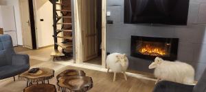 two white sheep standing in a living room with a fireplace at Domek VIP Resort Willa Adrian Zakopane in Poronin
