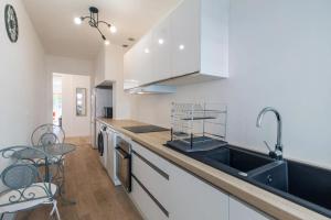 a kitchen with white cabinets and a sink at 2 Bedroom Ocean view Apartment in Nice