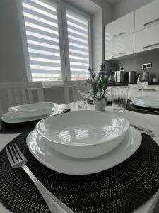 a table with a white plate and fork and wine glasses at Widok Kielce in Kielce