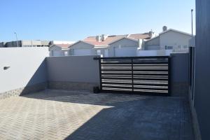 a gate on the side of a building with houses at Desert Nest II in Swakopmund