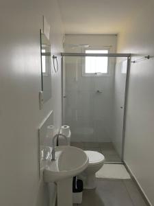 a bathroom with a shower and a toilet and a sink at Hotel Califórnia Cruz Alta in Cruz Alta