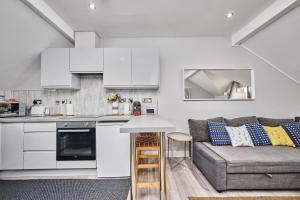 eine Küche und ein Wohnzimmer mit einem Sofa in der Unterkunft Princess Blue 3 ~ Portrush by the Sea in Portrush