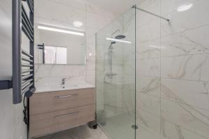 a bathroom with a glass shower with a sink and a tub at 2 Bedroom Ocean view Apartment in Nice +10 photos