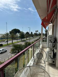 a balcony with two chairs and a view of a street at 2 Bedroom Ocean view Apartment in Nice